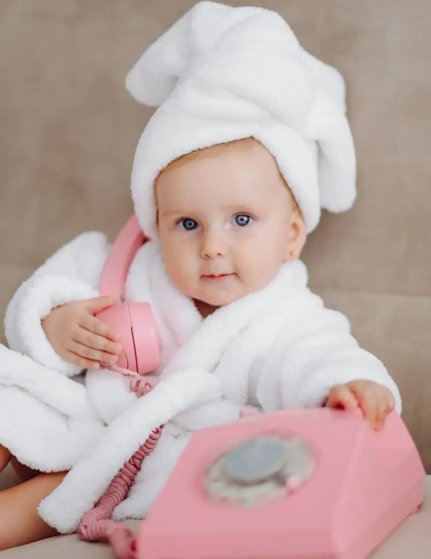 Cute baby girl in white bathrobe
